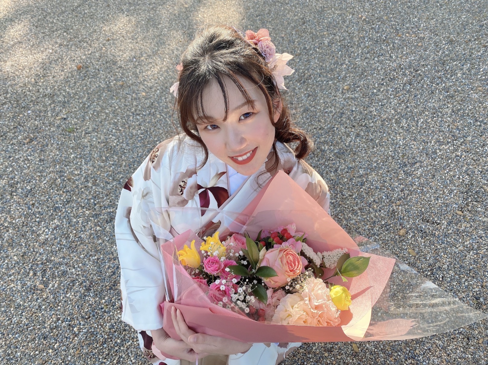 Mina in a kimono holding a bouquet of flowers